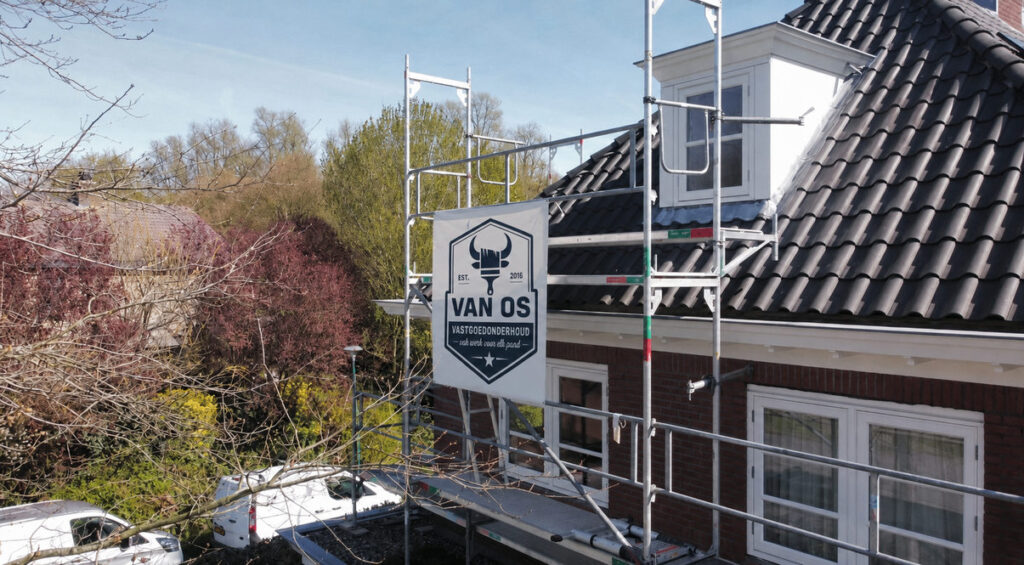 Steiger met Van Os-banner bij dakkapel en dak tijdens buitenschilderwerk aan een woning