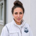 Dilara, oprichter van Van Os Vastgoedonderhoud, in bedrijfskleding voor een woning
